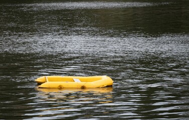 Solitary yellow dinghy floating peacefully on a calm river