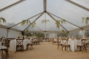 Elegant wedding reception under a clear tent.