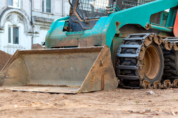 Fototapeta premium Tractor at a construction site. City street improvement is underway.