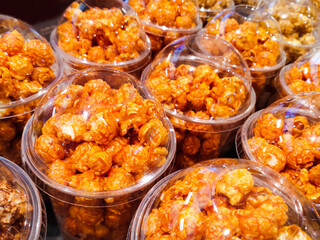 Caramel Popcorn in plastic cups and neatly arranged are often sold in cinema canteens. Can be used for food menu photos