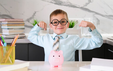Happy schoolboy with glasses is excited, who makes victorious gesture with his hands raised, smiles...