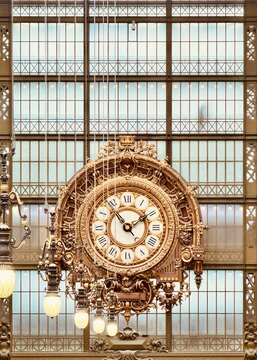 Paris, France: Orsay Museum Clock. An ornate gold clock set into the window wall of the old train station
