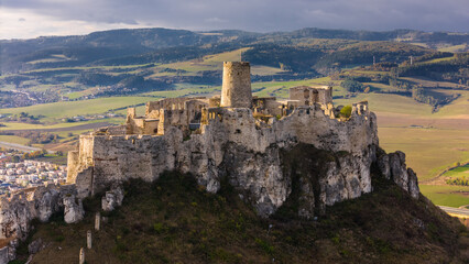 Obraz premium Breathtaking Aerial Drone View of Spis Castle Amidst Slovakia's Rolling Hills