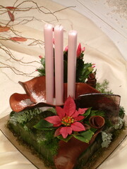Floral table decoration with three pink candles