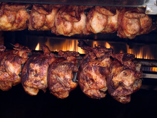 many chickens on the rotisserie Close-up shot of a steamy rotisserie machine window Grilled roasted whole chickens with tasty golden-yellow roasted skin on a turning spit in a row