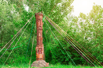 spring ritual pagan symbol statue wooden carved pillar May month bright sunny landscape in woods