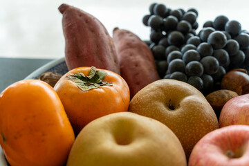 籠に入った秋の味覚：柿・林檎・梨・葡萄・薩摩芋