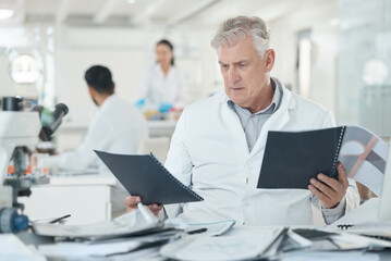 Science, laboratory and mature man with files for research, data management or pharmaceutical...