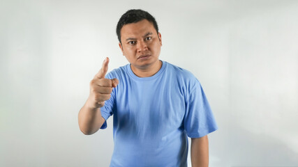 Fototapeta premium A young Indonesian man wearing a blue t-shirt with an angry face facing forward