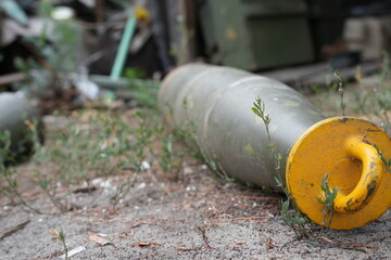 Obraz premium A close-up of military equipment with a yellow circular object in focus. Small plants grow amidst the machinery, symbolizing nature's resilience. 