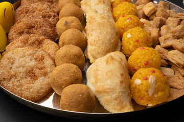 Indian sweets in a plate includes anarsa, shakkarpara morichoor  Bundi Laddu, Gujiya or Karanji for diwali celebration