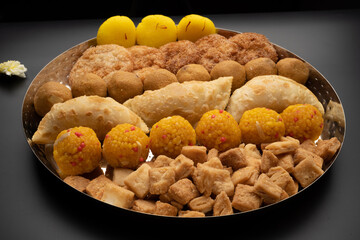 Indian sweets in a plate includes anarsa, shakkarpara morichoor  Bundi Laddu, Gujiya or Karanji for diwali celebration