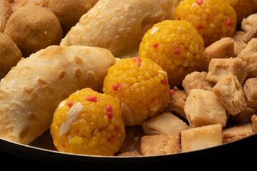 Indian sweets in a plate includes anarsa, shakkarpara morichoor  Bundi Laddu, Gujiya or Karanji for diwali celebration