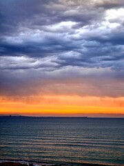 Obraz premium The setting sun over the horizon with a view of the sea