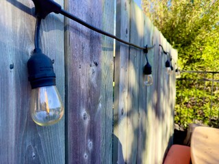 garlands of lights hanging on a wooden fence