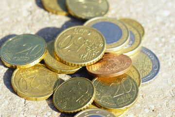 Close-up photographs of small denomination European Zone coins: one (1) and two (2) euros, as well as fifty (50), twenty (20), ten (10) and five (5) euro cents lying on the surface