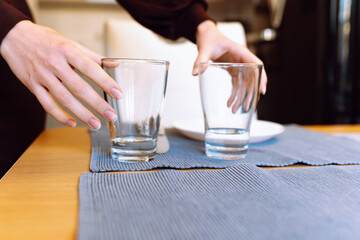 female hands clearing glass glasses from table