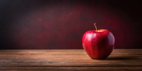 A lone red apple sits on a wooden table against a maroon background, table, maroon, still life