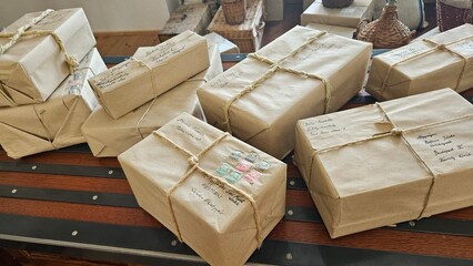 Pile of vintage wrapped packages tied with string on a wooden desk