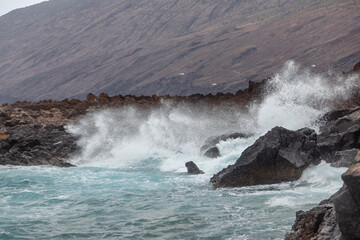 Obraz premium Powerful ocean waves crashing on volcanic rocks coastline