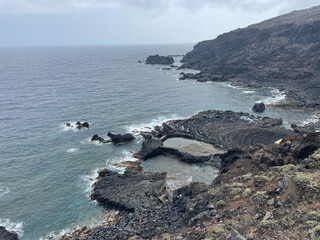 Waves crashing on volcanic rocks of el hierro canary islands coastline