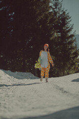  A girl with a snowboard in her hands against the backdrop of snowy mountains