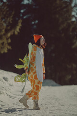  A girl with a snowboard in her hands against the backdrop of snowy mountains