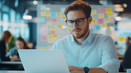 Young Man Working in Busy Office with Sticky Notes