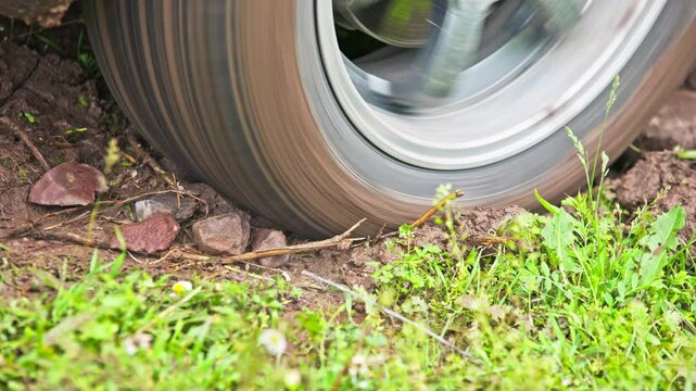 car tire slipping while stuck in a dirt, heating up and steaming in attempt to get free, closeup with selective focus