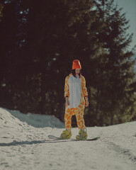  A girl with a snowboard in her hands against the backdrop of snowy mountains