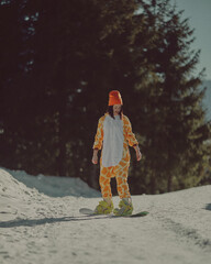  A girl with a snowboard in her hands against the backdrop of snowy mountains