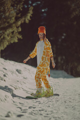  A girl with a snowboard in her hands against the backdrop of snowy mountains
