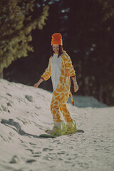  A girl with a snowboard in her hands against the backdrop of snowy mountains