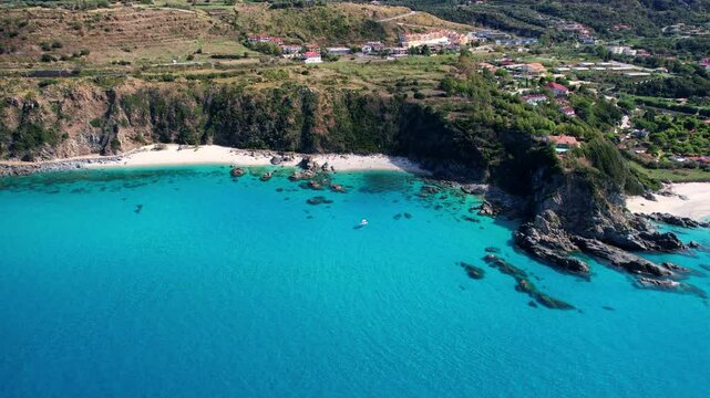 4K Aerial drone video of one of the most beautiful beaches in the world with turquoise clear blue water and white sand with big rocks on a sunny summer day. Marinella di Zambrone Paradiso Tropea Italy