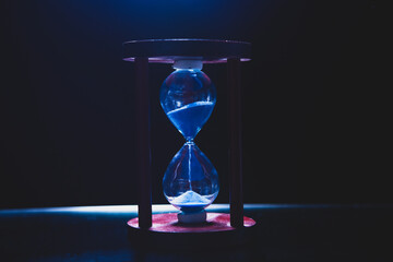 hourglass on a black background with a sand