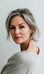 A woman with gray hair in a gray sweater.