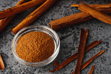 Closeup of Aromatic Ground Cinnamon and Sticks on a White Background