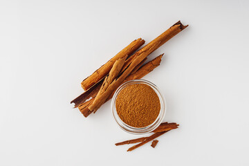 Closeup of Aromatic Ground Cinnamon and Sticks on a White Background