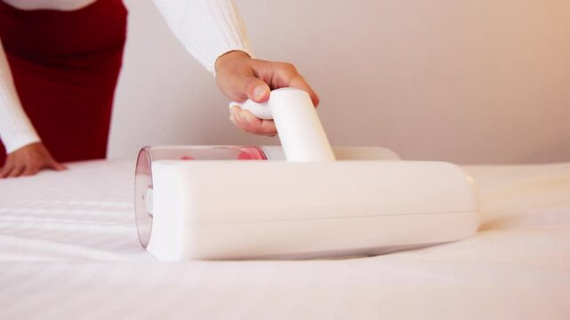 Woman vacuuming bed linen. Vacuum cleaners and germicidal dust mites with ultraviolet light to clean all beds, sofas and bedding. Health care concept House cleaning and good health