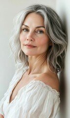 A woman with gray hair wearing a white blouse.