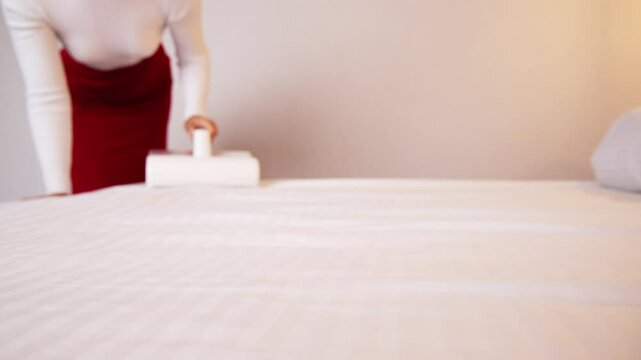 Woman vacuuming bed linen. Vacuum cleaners and germicidal dust mites with ultraviolet light to clean all beds, sofas and bedding. Health care concept House cleaning and good health