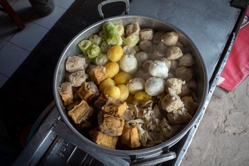 Siomay, fish cake dumplings with potato, rolled cabbage, and egg served with peanut sauces