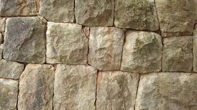 Smooth camera pan revealing a perfectly formed medieval stone wall made of large stones
