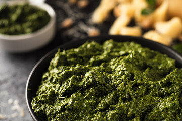 Homemade Pesto Sauce with Pine Nuts and Basil: Ingredients on Black Background
