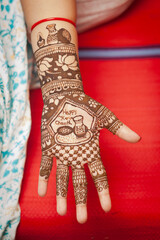 A close-up of an Indian woman's hand decorated with henna designs, captured during the Karva chauth...