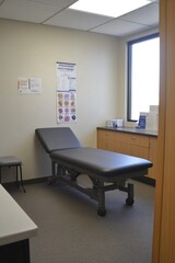 Fototapeta premium A medical examination room with a treatment table and minimal furnishings.