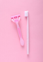 Personal hygiene items. Toothbrush with razor on pink background