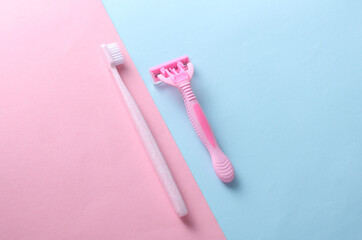 Razor with toothbrush on blue pink background. Top view