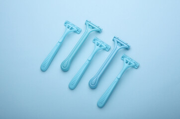 Blue disposable razors on blue background. Top view