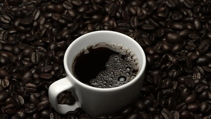 Top view of coffee or espresso with piles of coffee beans. Close up of fresh roasted coffee bean scatter around wooden table with cup of americano and aromatic stream and smoke from seed. Comestible.